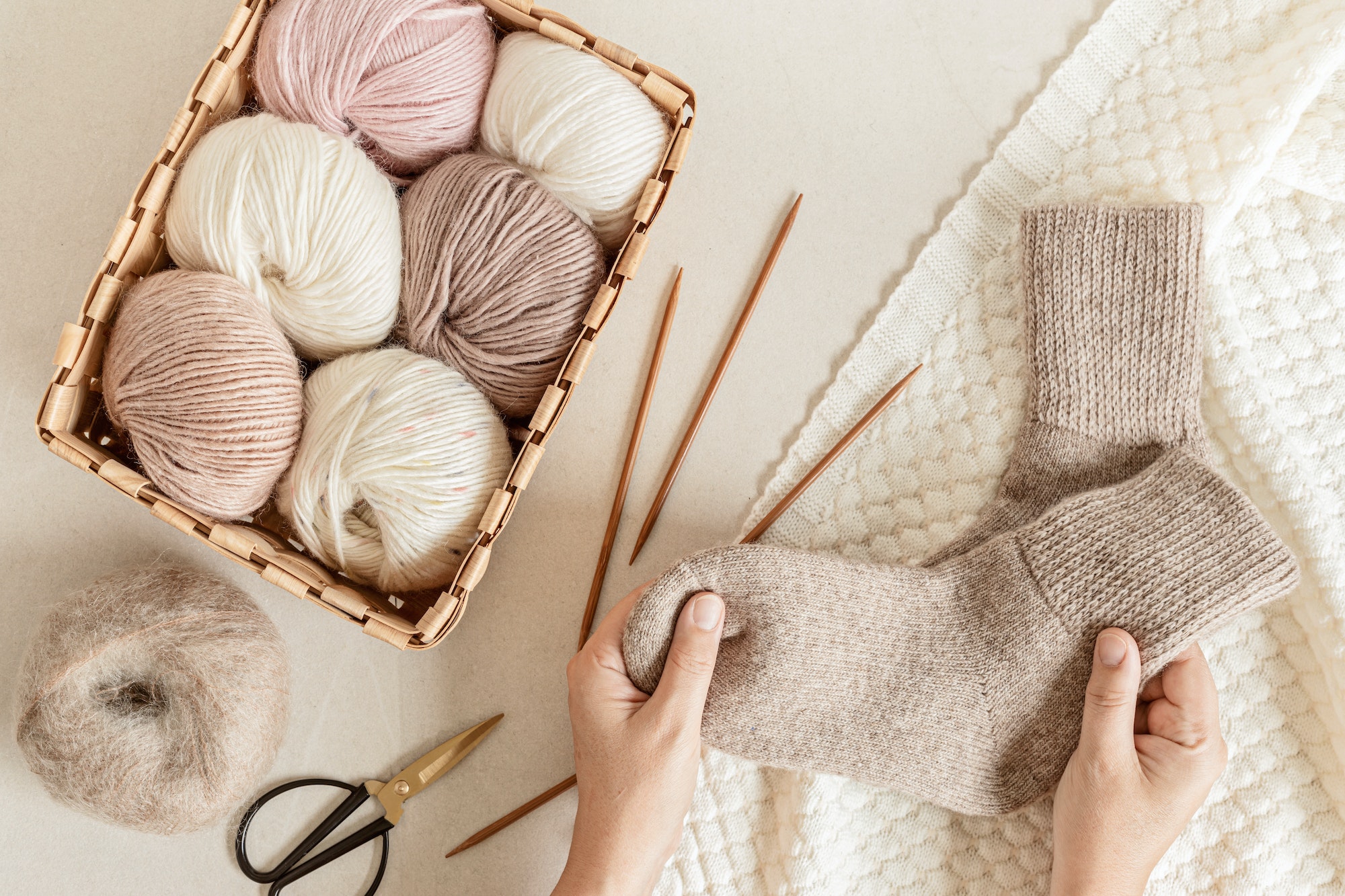 Craft hobby background with yarn in natural colors and handmade socks
